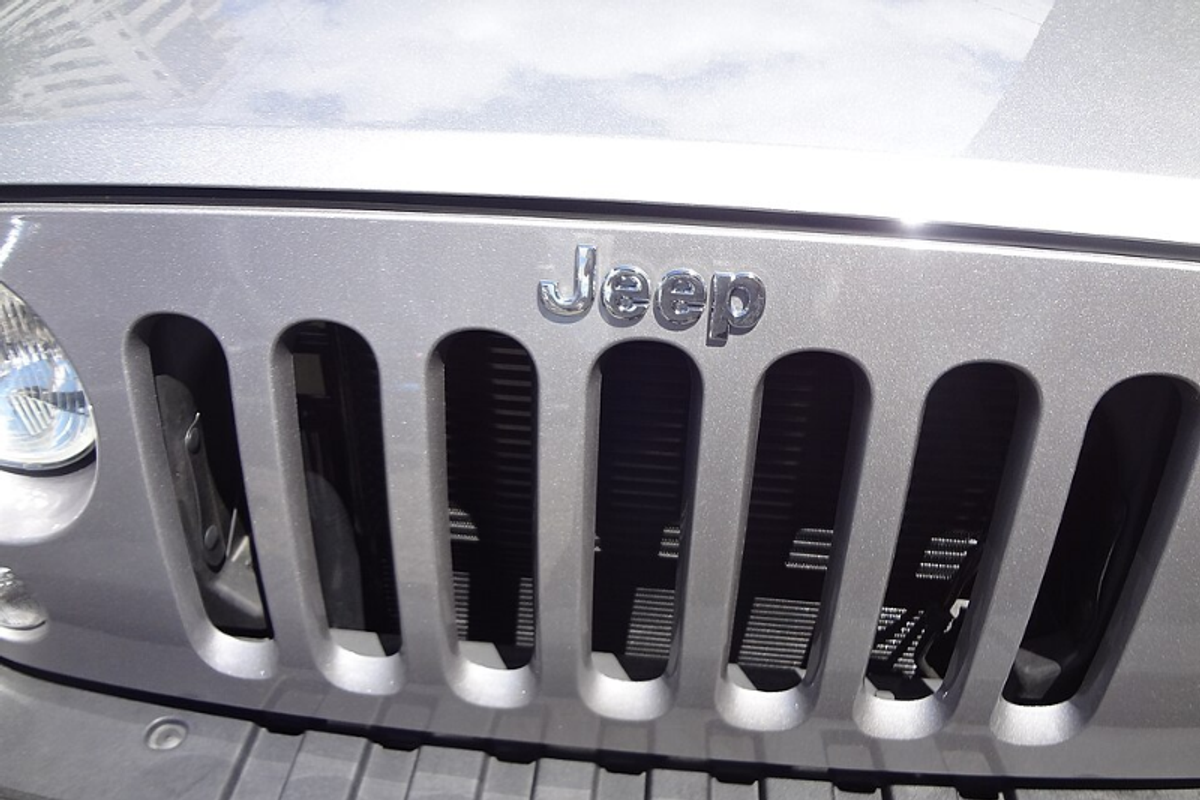 Jeep vehicle badge showing the Helvetica Bold wordmark in chrome on a rugged grille
